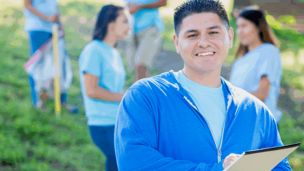 Man wearing blue zip up hoodie and carrying clipboard