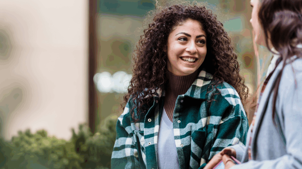Woman wearing plaid shirt smiling at someone