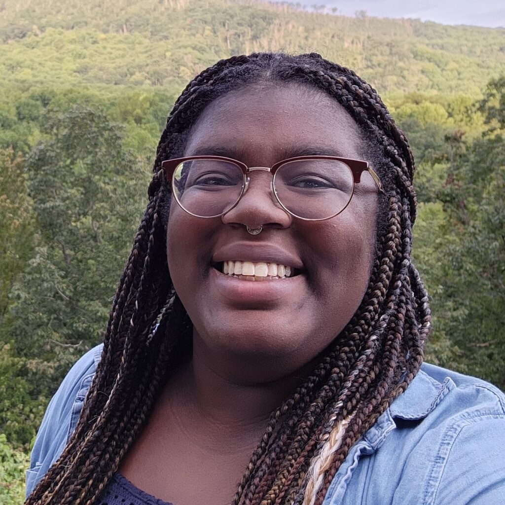 Amira Malcom in front of forested mountains